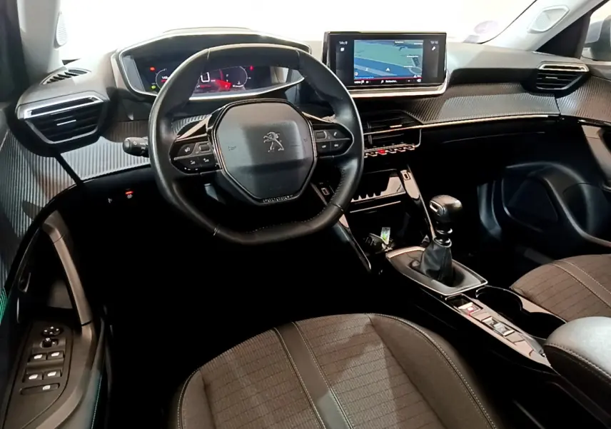 Intérieur du Peugeot 2008 PureTech 130 vue côté conducteur, volant cuir, écran tactile navigation et boîte manuelle noire.