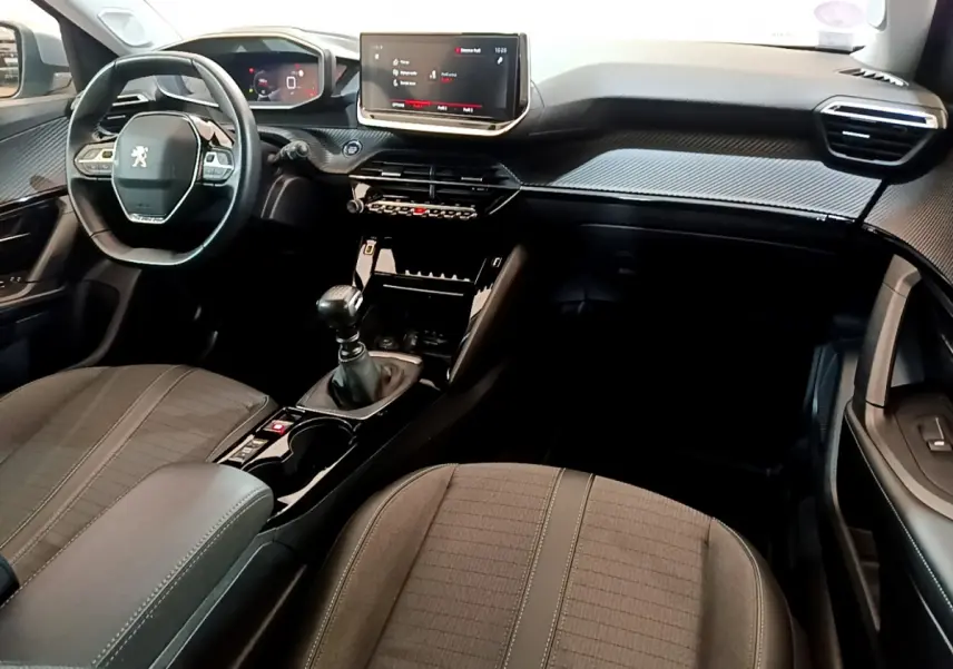 Intérieur noir de la Peugeot 2008 PureTech 130, vue depuis le siège passager avec tableau de bord et écran tactile central.