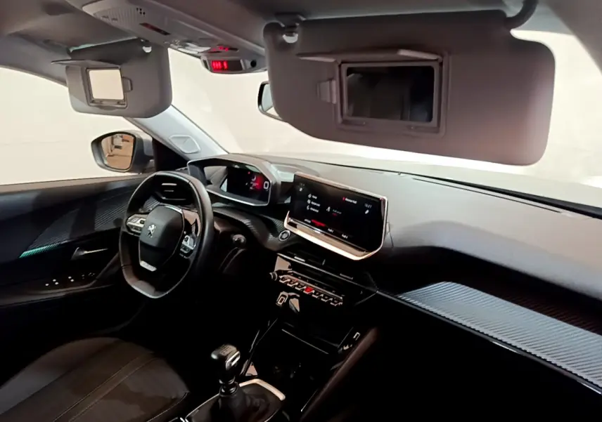 Intérieur avant du Peugeot 2008 gris clair, tableau de bord avec écran tactile et volant multifonctions cuir.