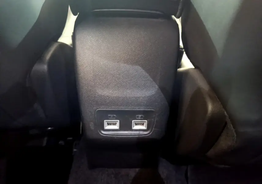 Vue rapprochée des ports USB arrière noirs entre les sièges arrière du Peugeot 2008 gris clair de 2021.