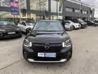 Vue de face d'une Citroën C3 1.2 turbo noire 2025, avec calandre distinctive et phares LED, stationnée en extérieur.