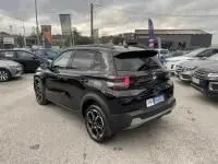 Vue 3/4 arrière droite d'une Citroën C3 1.2 turbo noire 2025, avec jantes noires et toit contrasté, sur un parking extérieur.