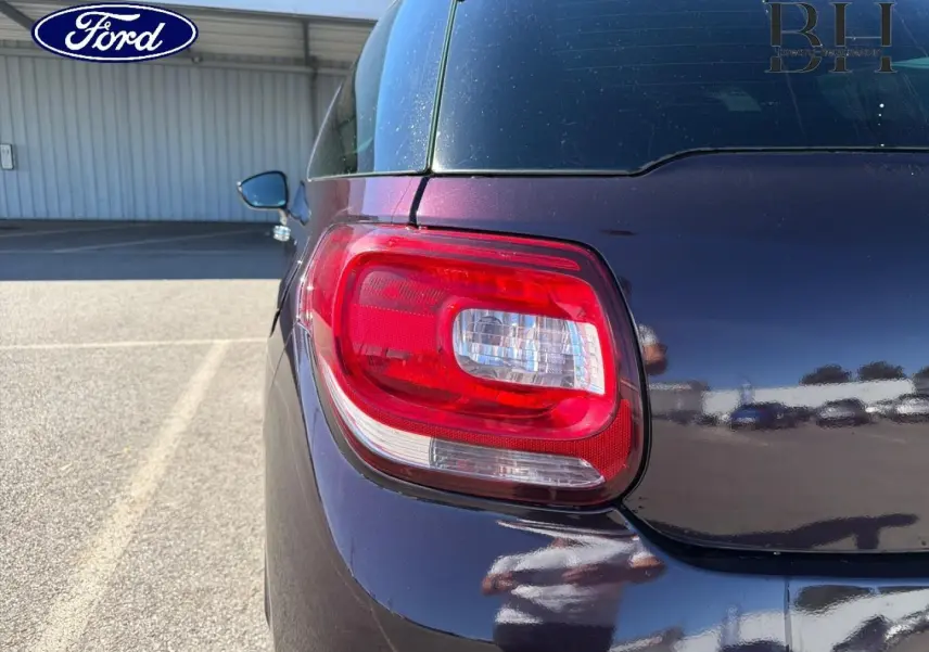 Feu arrière gauche en gros plan d'une Citroën DS3 rouge Rubi 2014, avec reflet sur la carrosserie brillante.