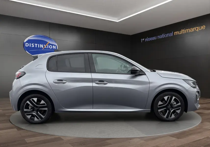 Peugeot 208 gris clair vue de profil côté gauche, avec jantes noires et détails modernes visibles.