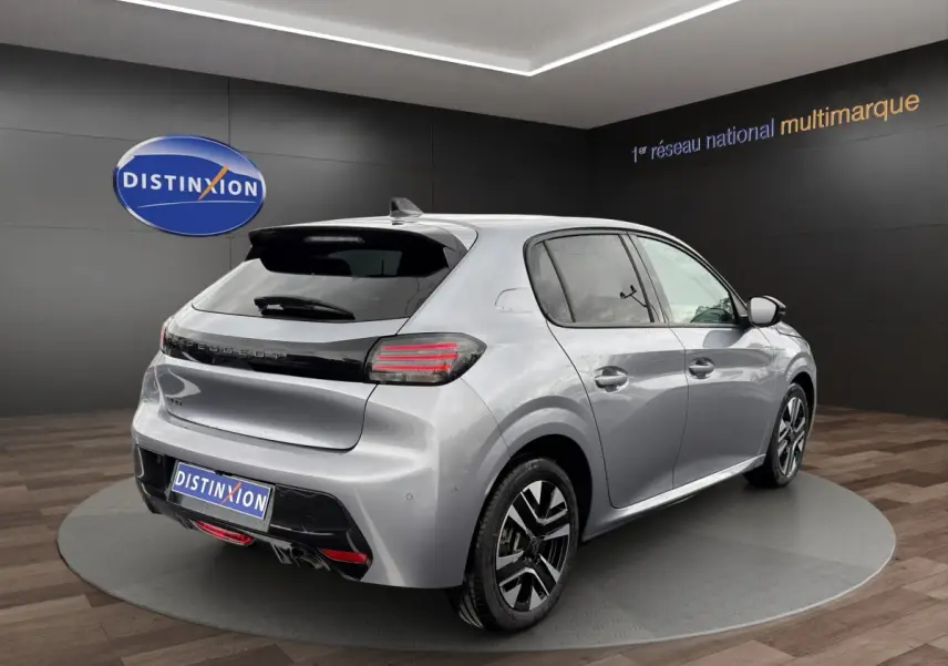 Vue 3/4 arrière droite d'une Peugeot 208 gris clair 2025 avec feux arrière LED et jantes alliage distinctives.