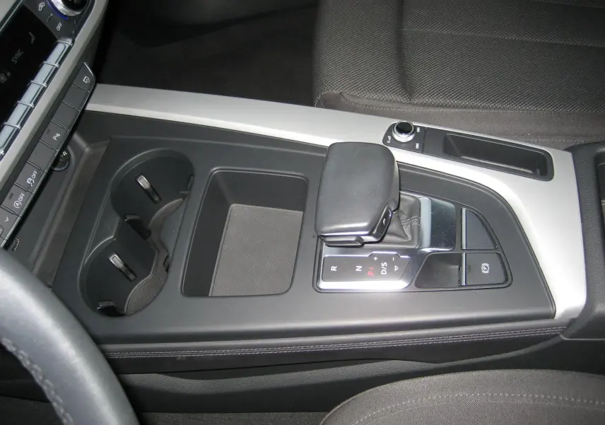 Vue rapprochée de la console centrale noire de l'Audi A4 Avant 3.5 TDI 2022 avec levier de boîte automatique et porte-gobelets.