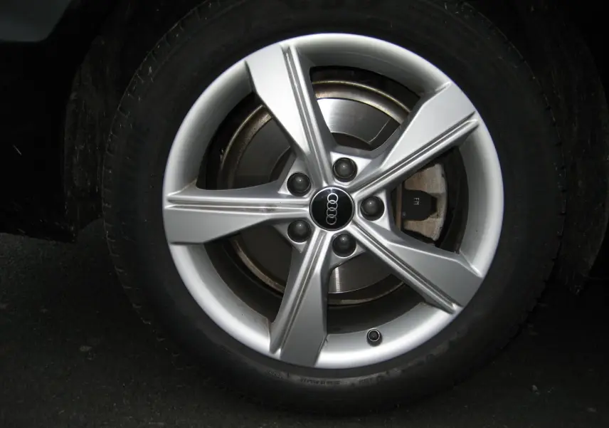 Gros plan sur la jante argentée de l'Audi A4 Avant 3.5 TDI 163 S Tronic Design noire, mettant en valeur le logo Audi central.