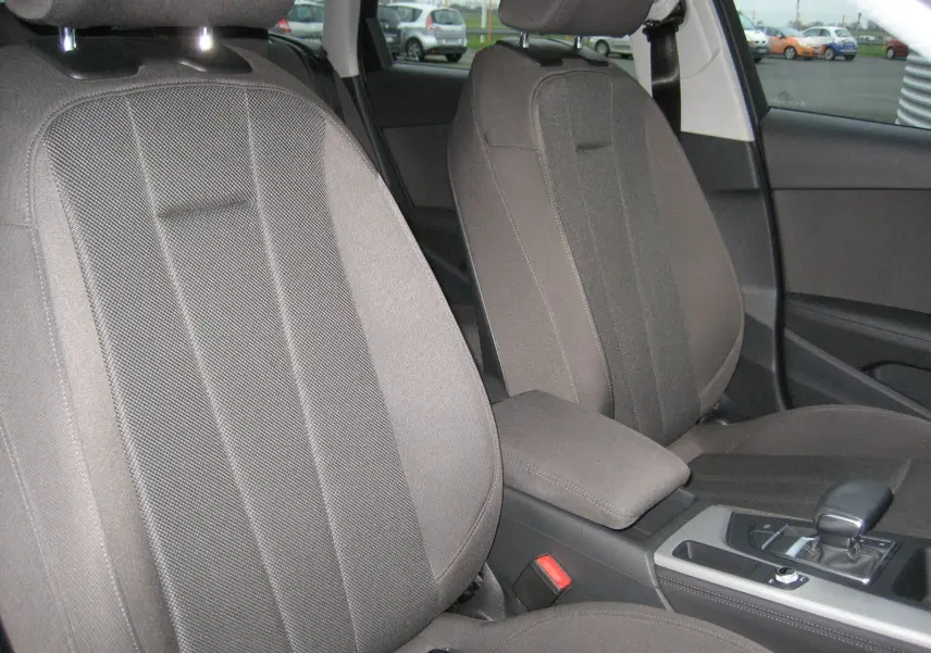 Vue rapprochée des sièges avant gris et de la console centrale d'une Audi A4 Avant noire de 2022 avec boîte automatique.