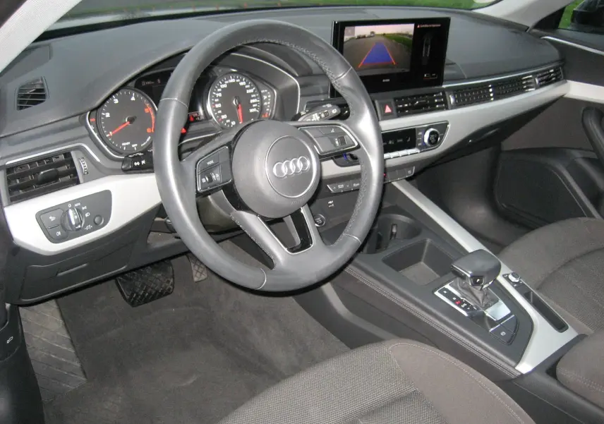 Intérieur Audi A4 Avant 2022 vu côté conducteur, tableau de bord noir avec écran central et levier de boîte automatique.