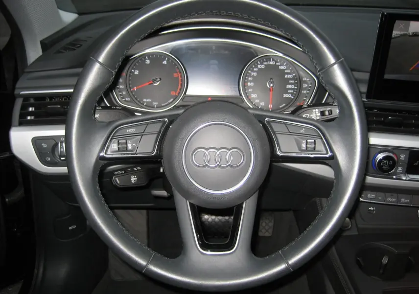 Vue rapprochée du volant en cuir noir d'une Audi A4 Avant 2022, avec tableau de bord et commandes visibles.