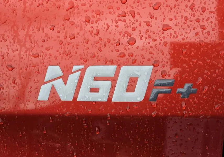 Gros plan sur l’inscription N60 F+ sur la carrosserie orange métallisée d’un Isuzu D-MAX III NEW 2025.