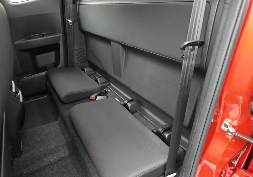 Vue latérale intérieure du siège arrière rabattable noir du pick-up Isuzu D-MAX orange métallisé, porte ouverte côté droit.