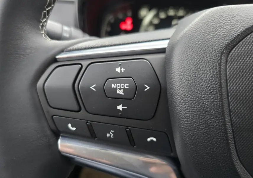 Gros plan sur les commandes audio et téléphone au volant en cuir noir de l'Isuzu D-MAX III NEW 2025.