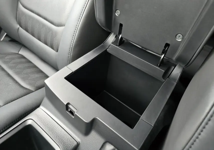 Coffre de rangement central ouvert avec intérieur noir, siège en cuir gris foncé de l'Isuzu D-MAX III NEW 2025.