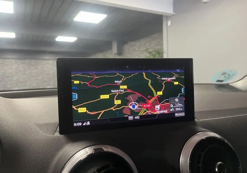 Écran central du système de navigation Audi Q2 2024 affichant une carte routière colorée en intérieur du véhicule.