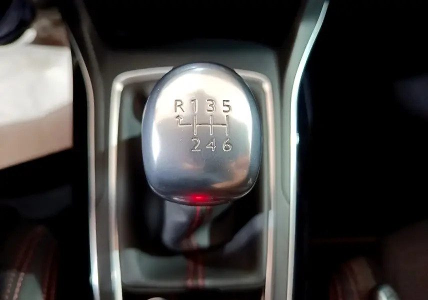 Le levier de vitesses manuel argenté de la Peugeot 308 GT Line blanc, vu en gros plan intérieur.