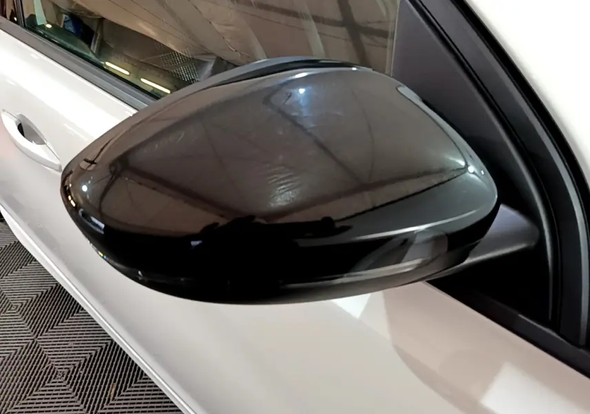 Rétroviseur noir côté gauche en gros plan sur Peugeot 308 blanc, version GT Line 2019, vue partielle latérale.