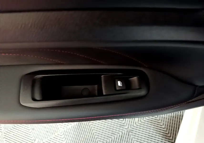 Gros plan sur la commande de lève-vitre côté gauche, garniture noire avec surpiqûres rouges, Peugeot 308 blanc 2019.