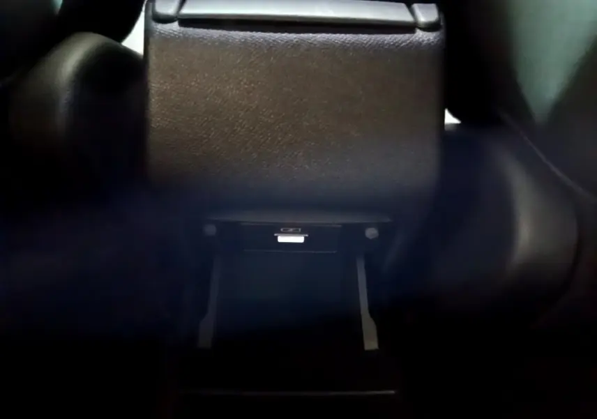 Gros plan sur la console centrale arrière noire du Peugeot 308 GT Line 2019, avec compartiment ouvert.