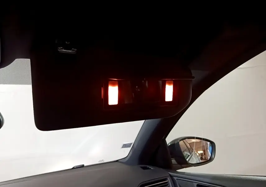 Détail intérieur du pare-soleil avec miroir éclairé côté droit sur Peugeot 308 blanc, vue depuis le siège conducteur.