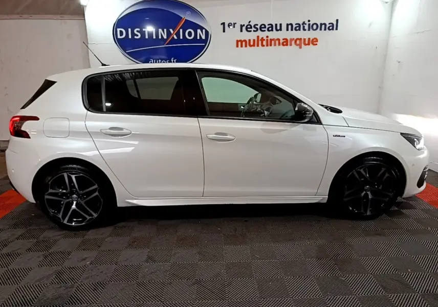 Profil droit d'une Peugeot 308 blanche Puretech 130 GT Line avec jantes noires et logo GT Line sur aile avant.