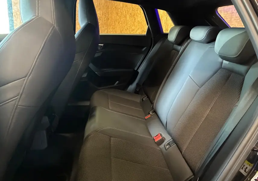 Vue intérieure côté droit montrant la banquette arrière en cuir noir de l'Audi A3 Sportback 2023 S line.