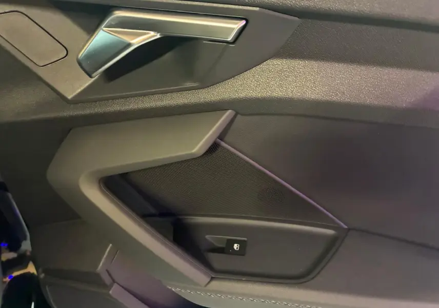 Vue rapprochée de la poignée intérieure côté gauche en similicuir noir avec insert aluminium sur Audi A3 Sportback 2023.