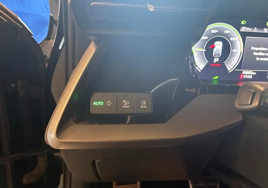 Gros plan sur les commandes d’éclairage à gauche du tableau de bord d’une Audi A3 Sportback noire, intérieur visible.