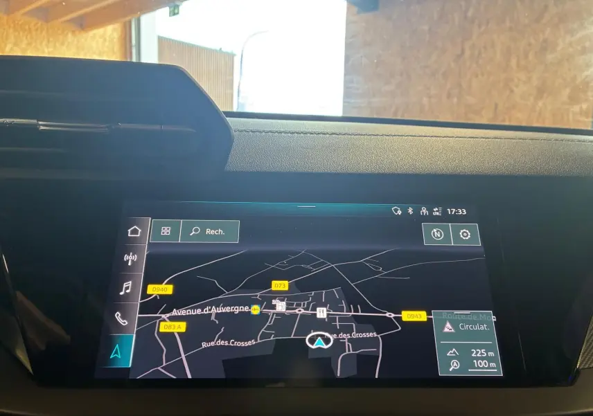 Écran tactile du système de navigation MMI plus dans l'habitacle de l'Audi A3 Sportback noir, vue frontale rapprochée.