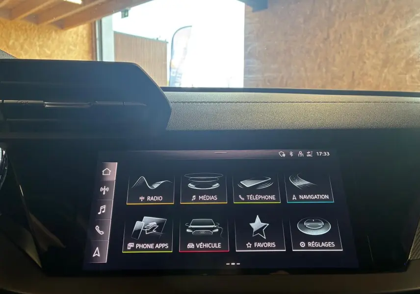 Écran tactile central de l'Audi A3 Sportback 2023 affichant le menu principal avec options multimédia et navigation.