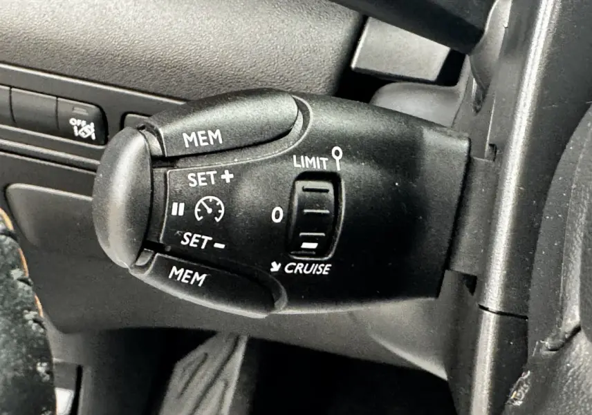 Gros plan sur la commande de régulateur de vitesse noire à gauche du volant du Citroën C3 Aircross 2020.