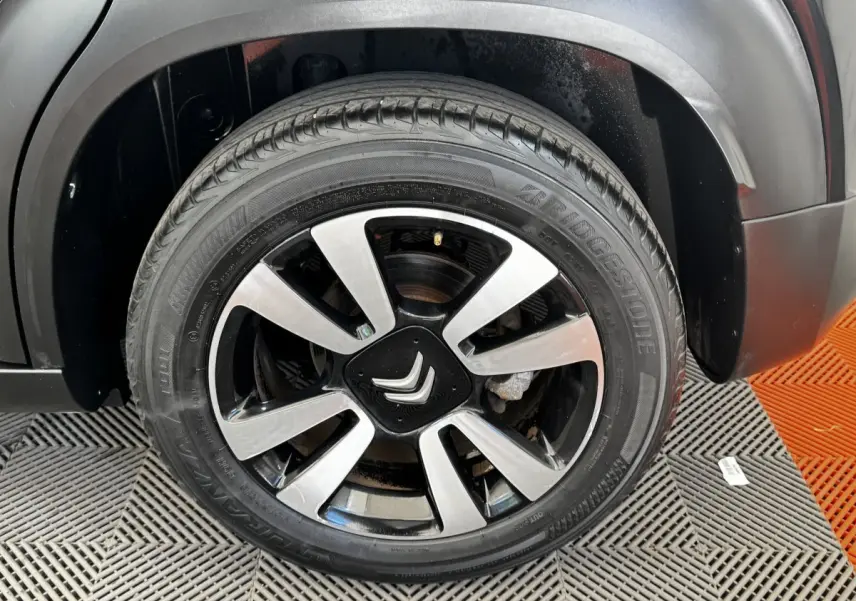Gros plan sur la roue avant droite noire avec jante alliage bicolore du Citroën C3 Aircross 2020.
