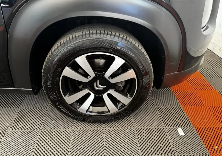 Gros plan sur la roue avant gauche noire d'une Citroën C3 Aircross 2020 avec jante alliage et logo Citroën central.