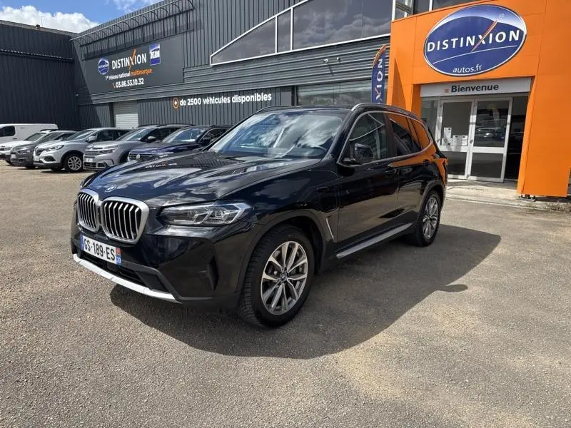 BMW X3 xDrive30e noir saphir métallisé en 3/4 avant droit, avec jantes alu et calandre chromée visible.