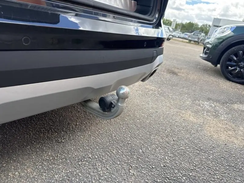 Vue rapprochée du crochet d'attelage électrique à l'arrière d'un BMW X3 xDrive30e Saphirschwarz métallisé 2023.
