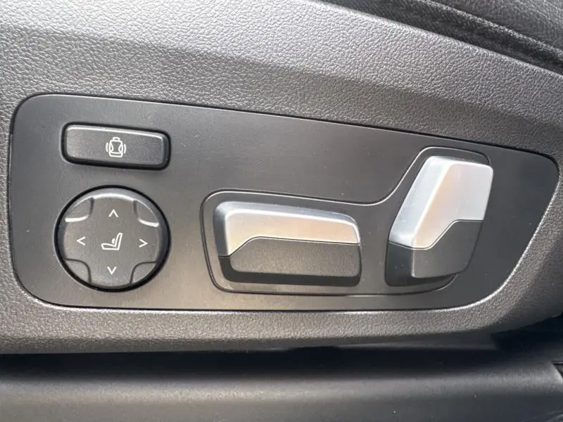 Gros plan sur les commandes électriques de réglage du siège avant noir dans un BMW X3 xDrive30e 2023.