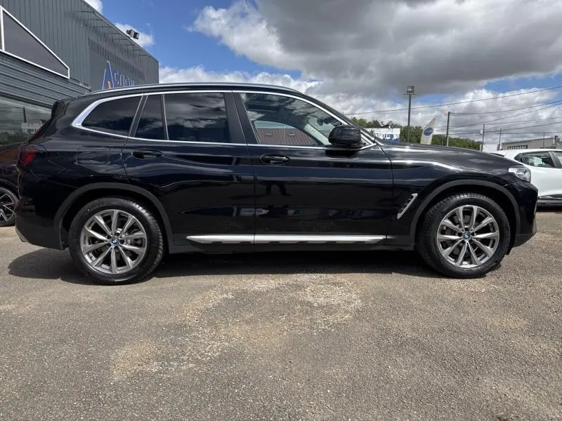 BMW X3 xDrive30e 2023 noir saphir, vue profil côté gauche, jantes alliage 19 pouces et toit panoramique visible.