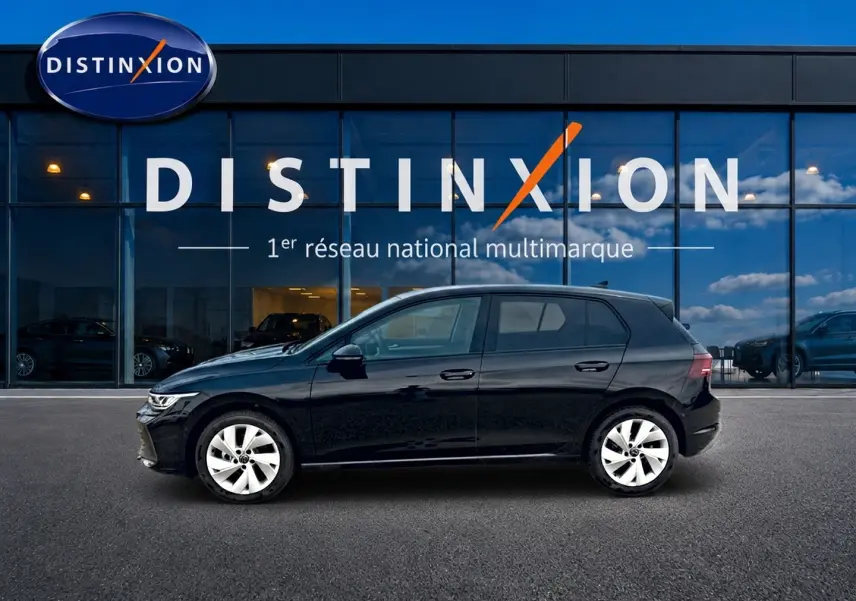 Volkswagen Golf 2026 noire vue de profil côté gauche devant une vitrine avec logo Distinxion.