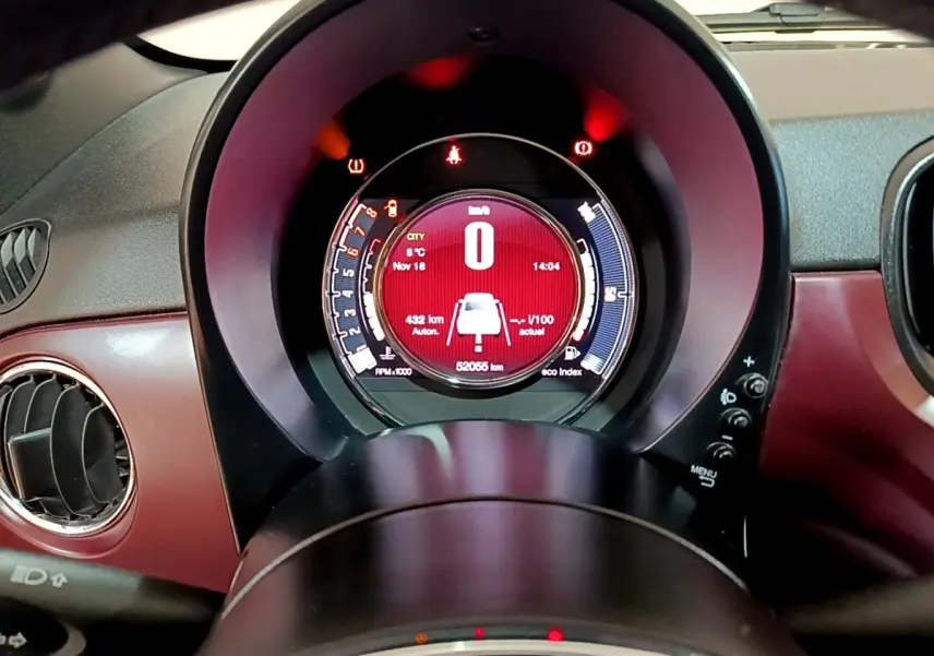 Vue rapprochée du tableau de bord rouge de la Fiat 500 1.0 70ch BSG Star avec affichage digital central lumineux.