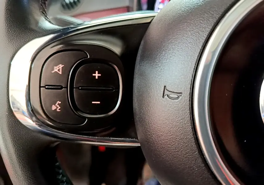 Gros plan sur les commandes gauche du volant cuir de la Fiat 500 rouge 1.0 70ch BSG Star de 2021.