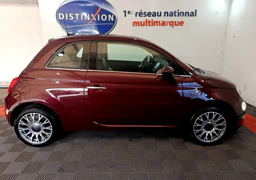 Profil droit d'une FIAT 500 rouge bordeaux 2021 avec jantes alliage et intérieur visible à travers les vitres.