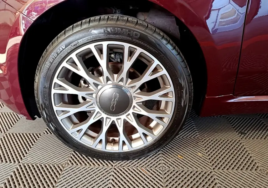 Gros plan sur la roue avant gauche d'une FIAT 500 rouge 2021 avec jante alliage multi-branches argentée