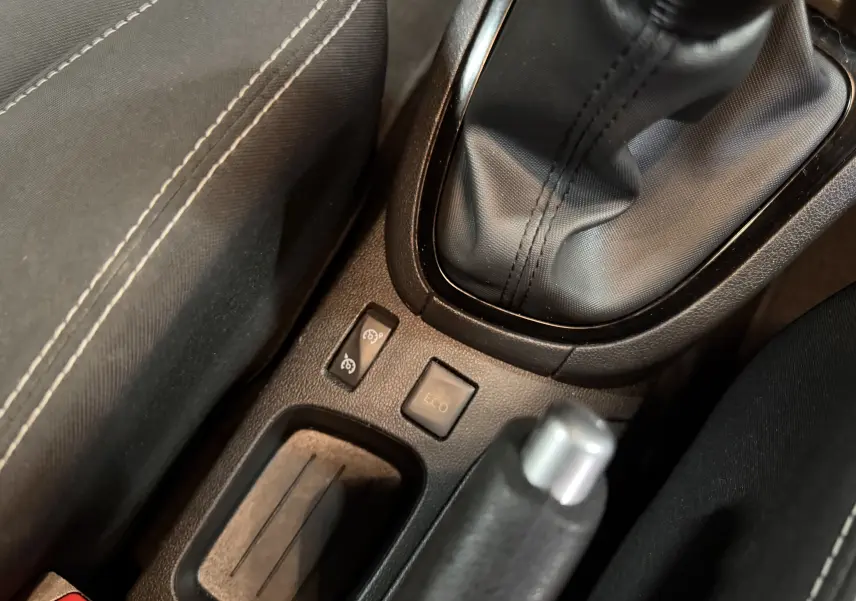 Gros plan sur la console centrale noire de la Renault Clio Estate IV rouge, montrant levier de vitesse manuel et bouton Eco.