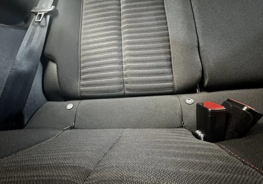 Vue rapprochée de la banquette arrière noire de la Peugeot 208 PureTech 100 S&S Active Business avec ceintures et fixations Isofix visibles.