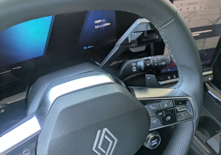 Gros plan sur le volant noir du Renault Austral 2025 avec commandes intégrées et levier de vitesses digital visible.