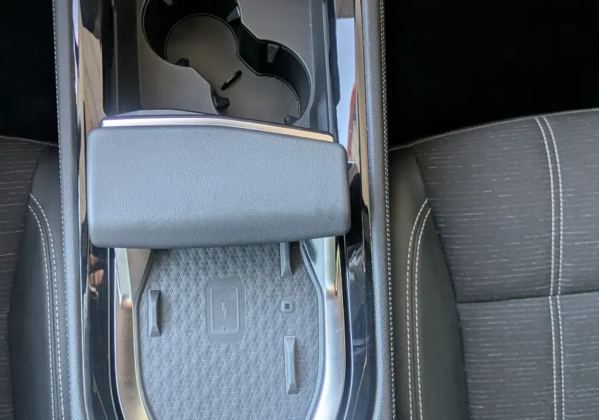 Vue plongeante sur la console centrale noire du Renault Austral 2025, avec porte-gobelets et accoudoir en cuir.
