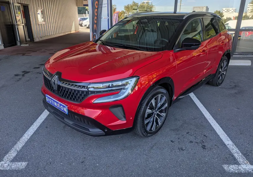 Renault Austral Rouge Flamme en 3/4 avant droit, avec toit panoramique noir et jantes alliage bicolores.