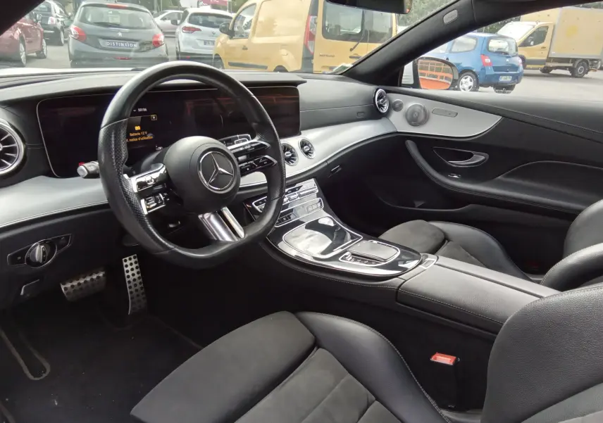 Intérieur noir de la Mercedes Classe E Coupé 220D AMG Line 2020, vue côté conducteur avec tableau de bord moderne.
