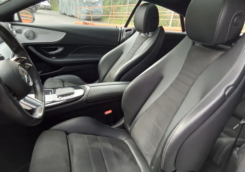 Intérieur noir cuir de la Mercedes Classe E Coupé 220D AMG Line, vue côté conducteur avec console centrale élégante.