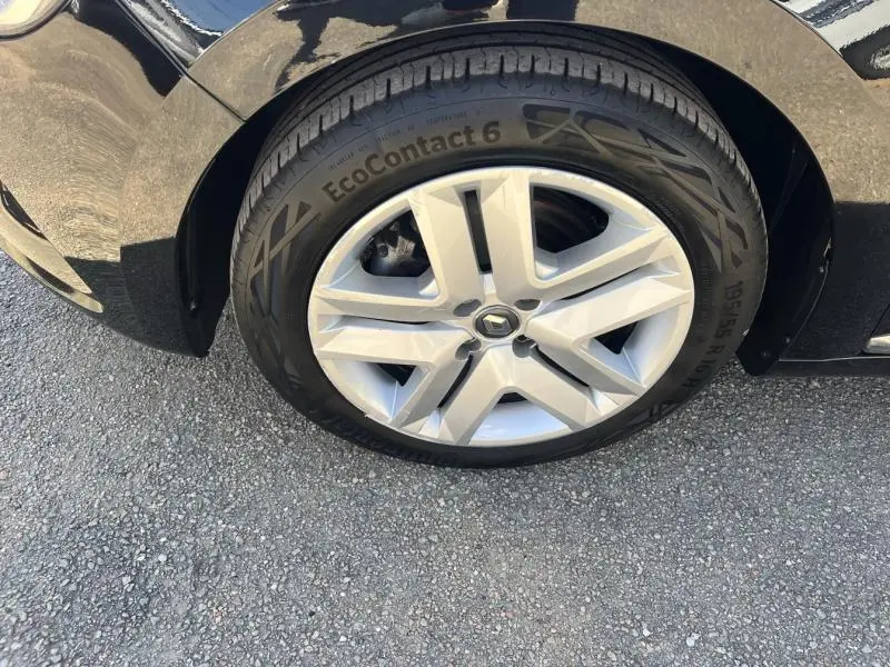 Gros plan sur la roue avant gauche de la Renault Clio 1.6 E-Tech 140ch Business noire avec jante alliage et pneu EcoContact 6.